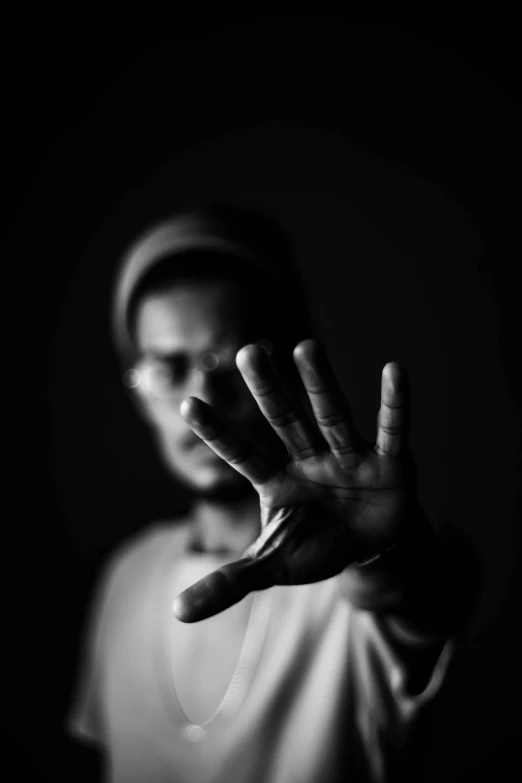 a person making a stop sign with their hands, a black and white photo, by Leo Leuppi, dramatic lighting man, riyahd cassiem, wave a hand at the camera, scissors in hand