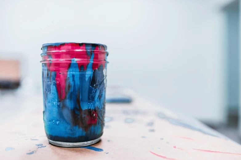 a jar of paint sitting on top of a table, inspired by Sam Francis, pexels, fuchsia and blue, two tone dye, indian ink, crafts