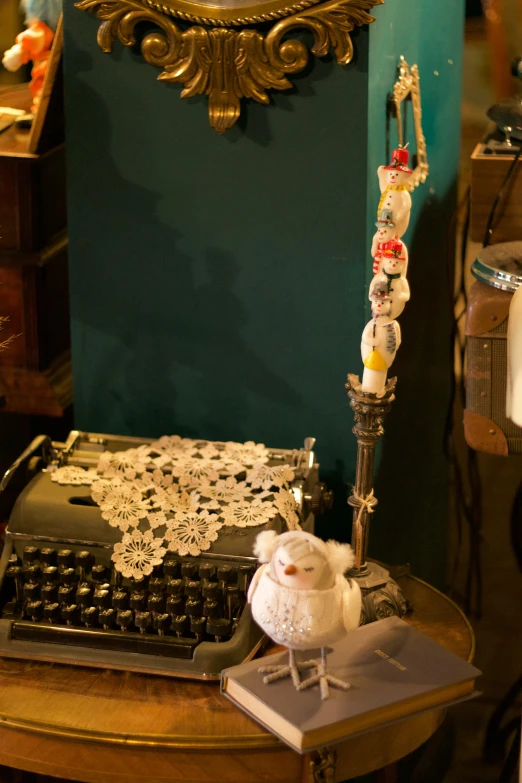 a typewriter sitting on top of a wooden table, inspired by Rube Goldberg, assemblage, floral lacework, on a candle holder, a steampunk store, looking towards camera