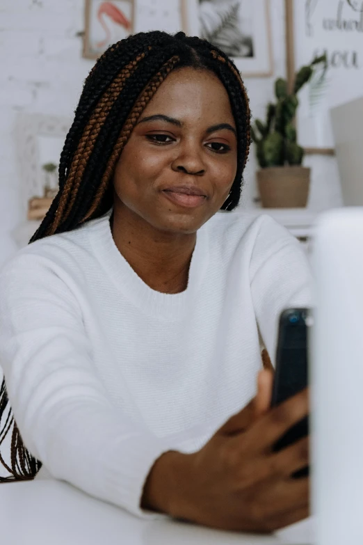 a woman sitting at a desk using a cell phone, trending on pexels, happening, portrait of ororo munroe, in front of the internet, high quality photo, avatar image