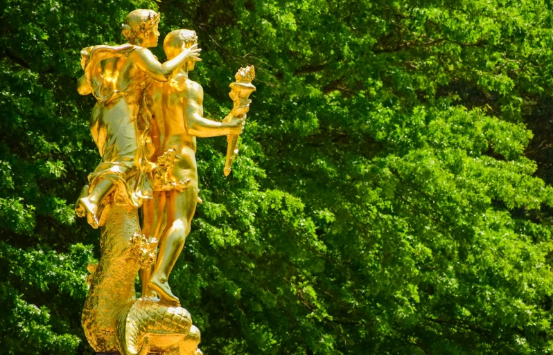 a golden statue in the middle of a park, by Werner Gutzeit, pexels contest winner, rococo, green, fauns, banner, 🦩🪐🐞👩🏻🦳