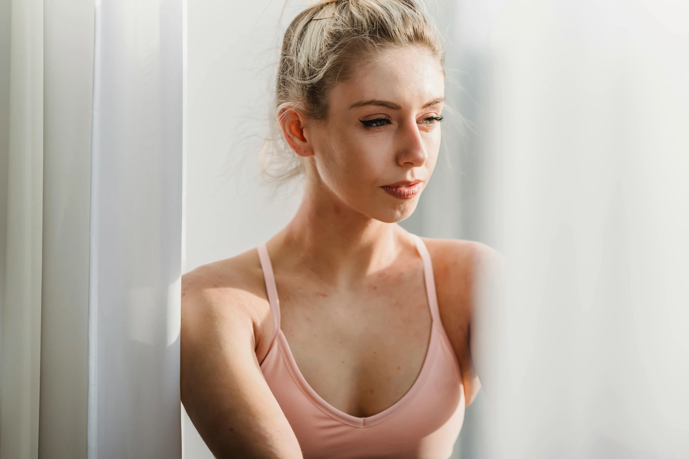 a beautiful young woman sitting in front of a window, trending on pexels, sweaty face, lachlan bailey, clean face and body skin, light stubble