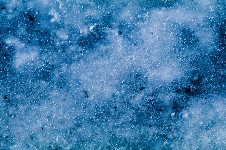 a person riding a snowboard down a snow covered slope, a microscopic photo, inspired by Vija Celmins, pexels, analytical art, blue nebula, background image, covered in water drops, blue-fabric