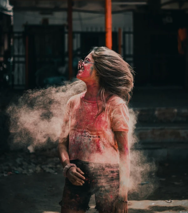 a woman covered in powder standing in front of a building, pexels contest winner, blood and dust in the air, portrait happy colors, gif, teenage girl