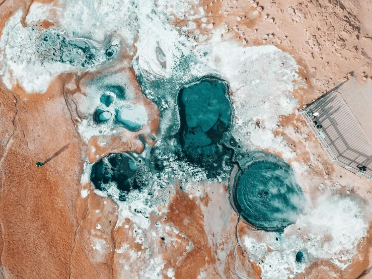 a large body of water sitting on top of a sandy beach, a microscopic photo, by Lee Loughridge, trending on unsplash, process art, pools, the australian desert, smelting pit'beeple, satellite view