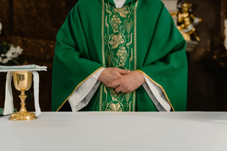 a priest standing in front of a white table, unsplash, green robe, paisley, thumbnail, 15081959 21121991 01012000 4k