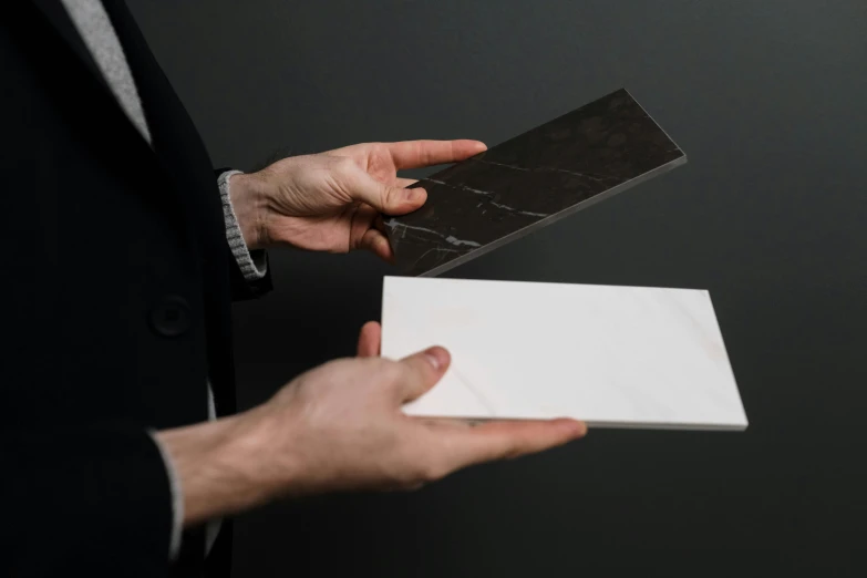 a man in a suit holding a piece of paper, by Matthias Stom, pexels contest winner, bauhaus, marble material, porcelain forcefield, light and dark, ultra-realistic