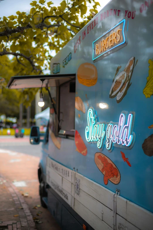 a food truck parked on the side of the road, by Jay Hambidge, trending on unsplash, graffiti, dimensional cyan gold led light, straya, iridescent glowing chips, gilded with gold