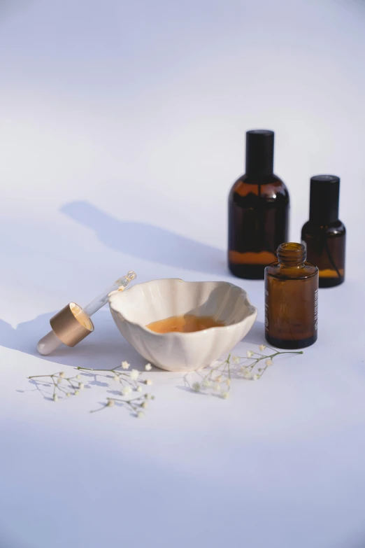 a white table topped with bottles of essential oils, a still life, unsplash, white petal, studio photo, brown, thumbnail