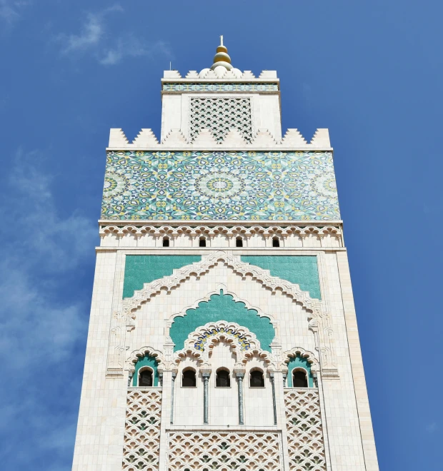 a tall tower with a clock on top of it, a mosaic, inspired by Alberto Morrocco, trending on unsplash, hurufiyya, white and teal metallic accents, islamic, square, blue sky