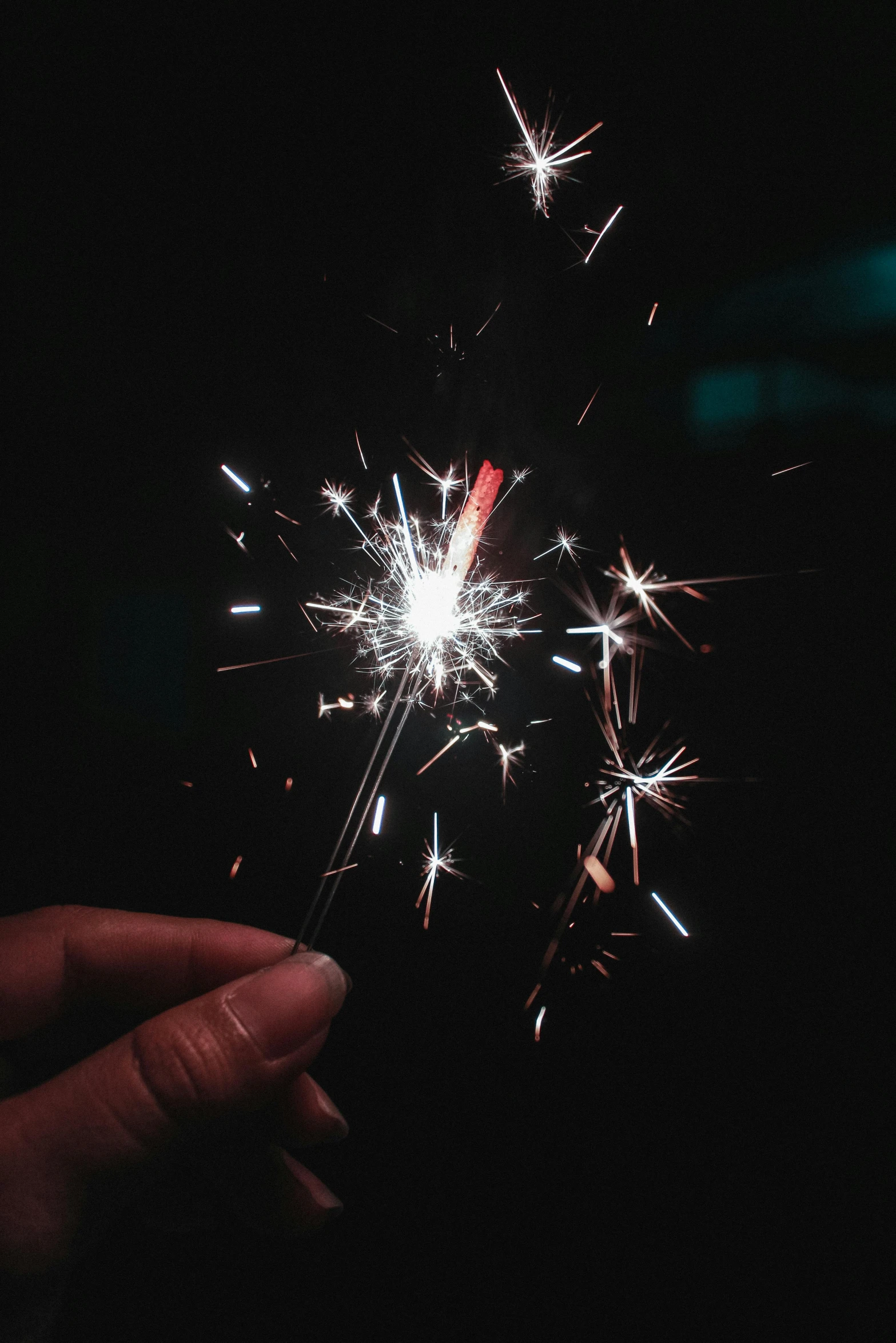 a person holding a sparkler in their hand, pexels, paul barson, sparkles and glitter, in 2 0 1 5, texture