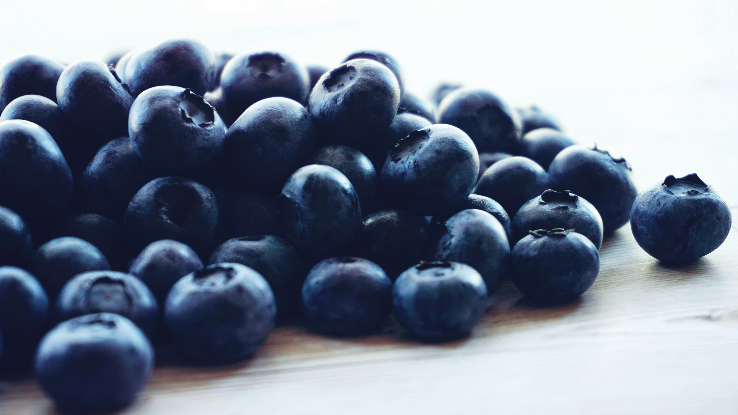 a pile of blueberries sitting on top of a wooden table, profile image, navy blue, uncrop, group photo