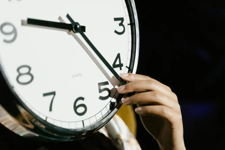 a close up of a person holding a clock, by Julia Pishtar, trending on pexels, hurufiyya, amanda clarke, digital image, thumbnail, 555400831