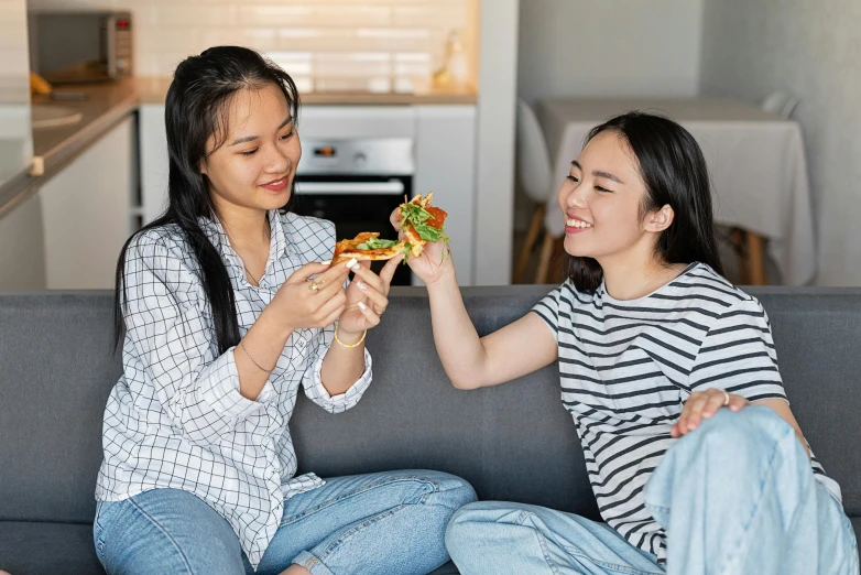 two women sitting on a couch eating sandwiches, inspired by Wang Duo, pexels contest winner, avatar image, teenager, cooking pizza, asian descent