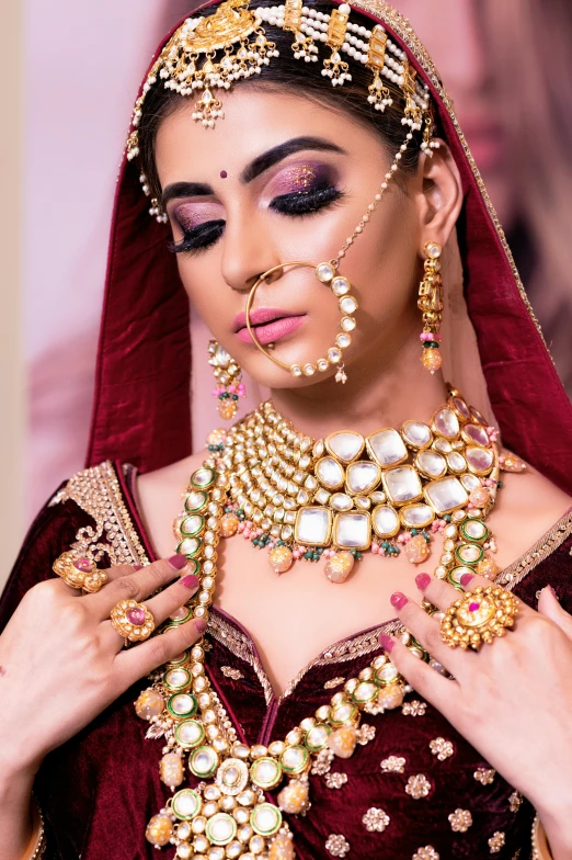 a woman in a maroon dress and gold jewelry, trending on pexels, indian, covered in jewels, pastel', square