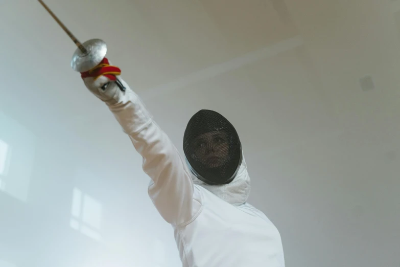 a man in a fencing suit holding a sword, pexels contest winner, arabesque, 2 0 2 1 cinematic 4 k framegrab, practising her sword staces, holding a white flag, indoor picture