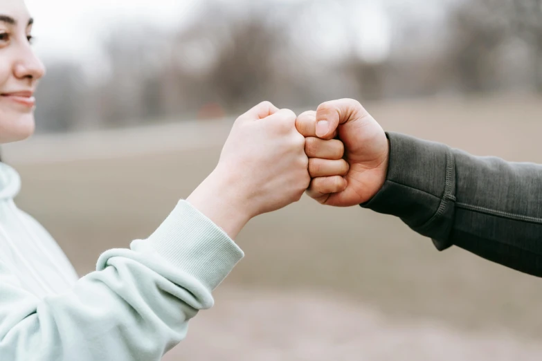 a man and a woman holding hands in a field, pexels contest winner, large fists, good friends, background image, punching
