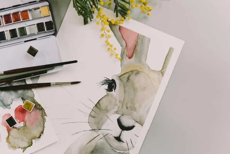 a close up of a painting of a rabbit, a watercolor painting, trending on pexels, arbeitsrat für kunst, on a desk, flatlay, animal caricaturist, art set