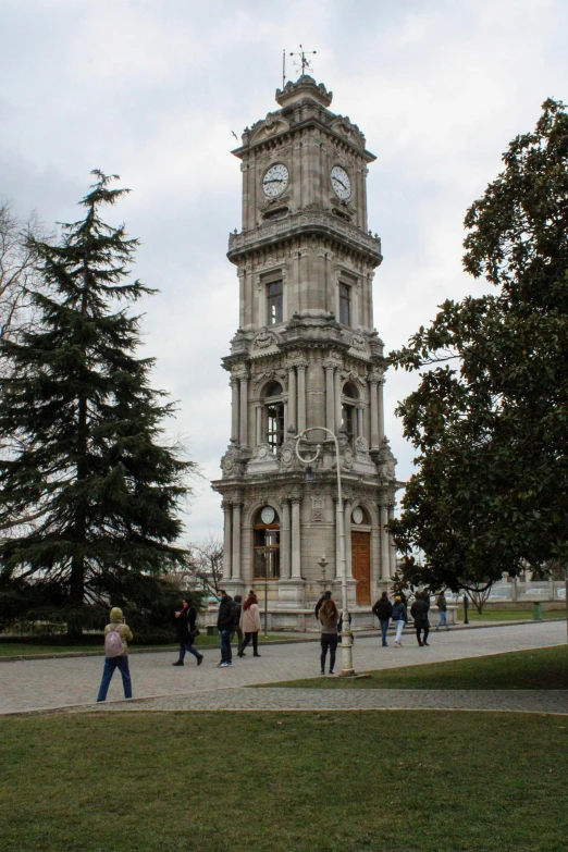 a tall clock tower sitting in the middle of a park, inspired by Altoon Sultan, baroque, white marble buildings, people walking around, byzantine, seen from outside