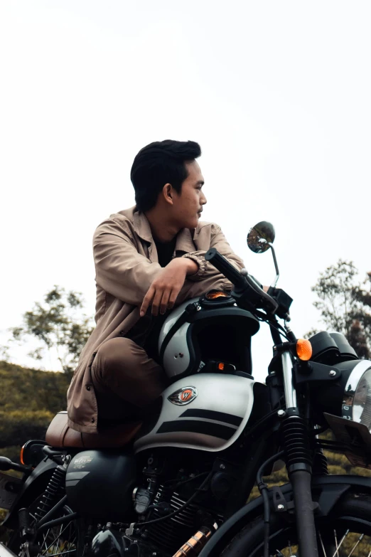 a man sitting on the back of a motorcycle, inspired by Rudy Siswanto, unsplash, realism, wearing a turtleneck and jacket, 👰 🏇 ❌ 🍃, a young man, brown