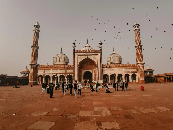 a group of people standing in front of a building, inspired by Steve McCurry, pexels contest winner, arabesque, with beautiful mosques, beautiful futuristic new delhi, thumbnail, brown