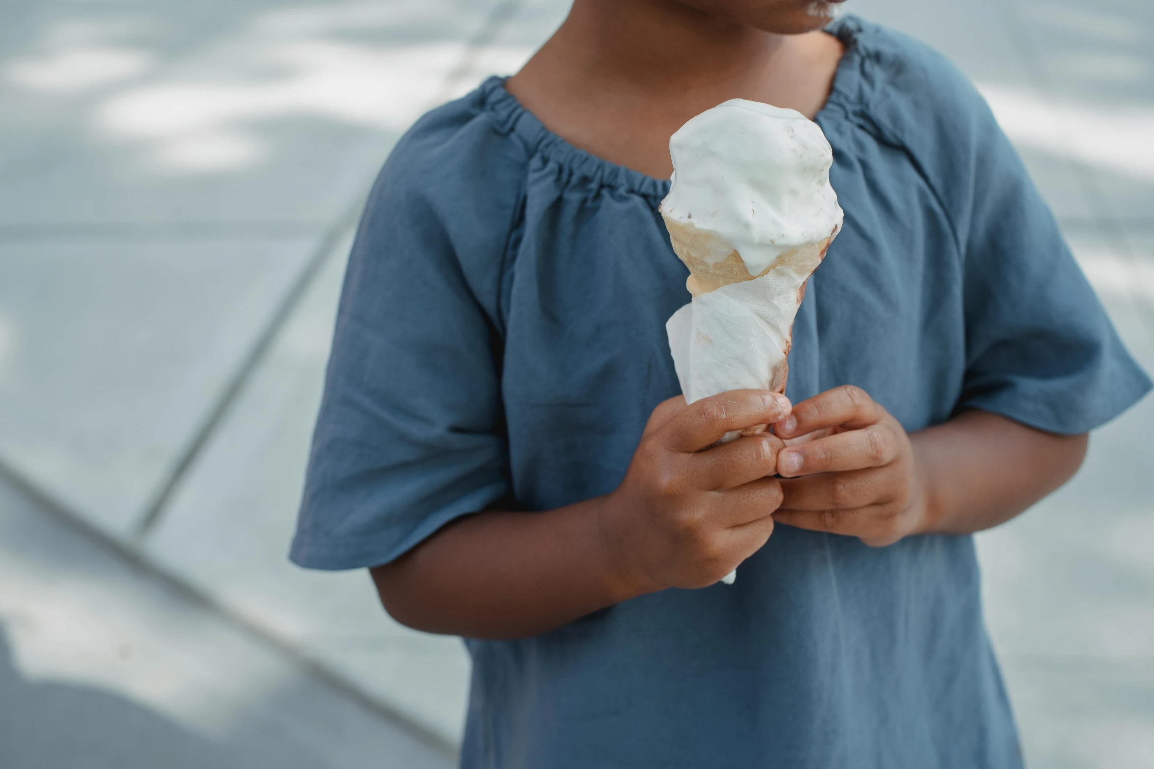 a little girl holding an ice cream cone, pexels contest winner, renaissance, white and pale blue toned, dark-skinned, crisp clean shapes, loosely cropped