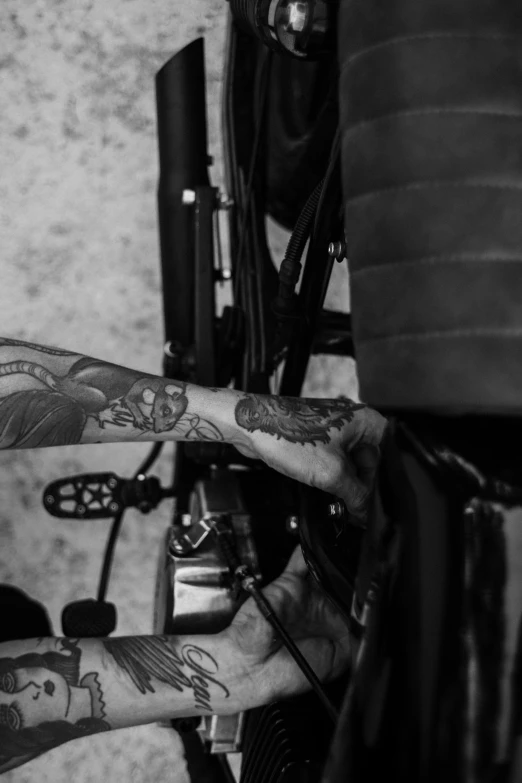 a man getting a tattoo on his arm, a tattoo, by Adam Marczyński, sitting on a motorcycle, cogs and wheels, structure : kyle lambert, uploaded