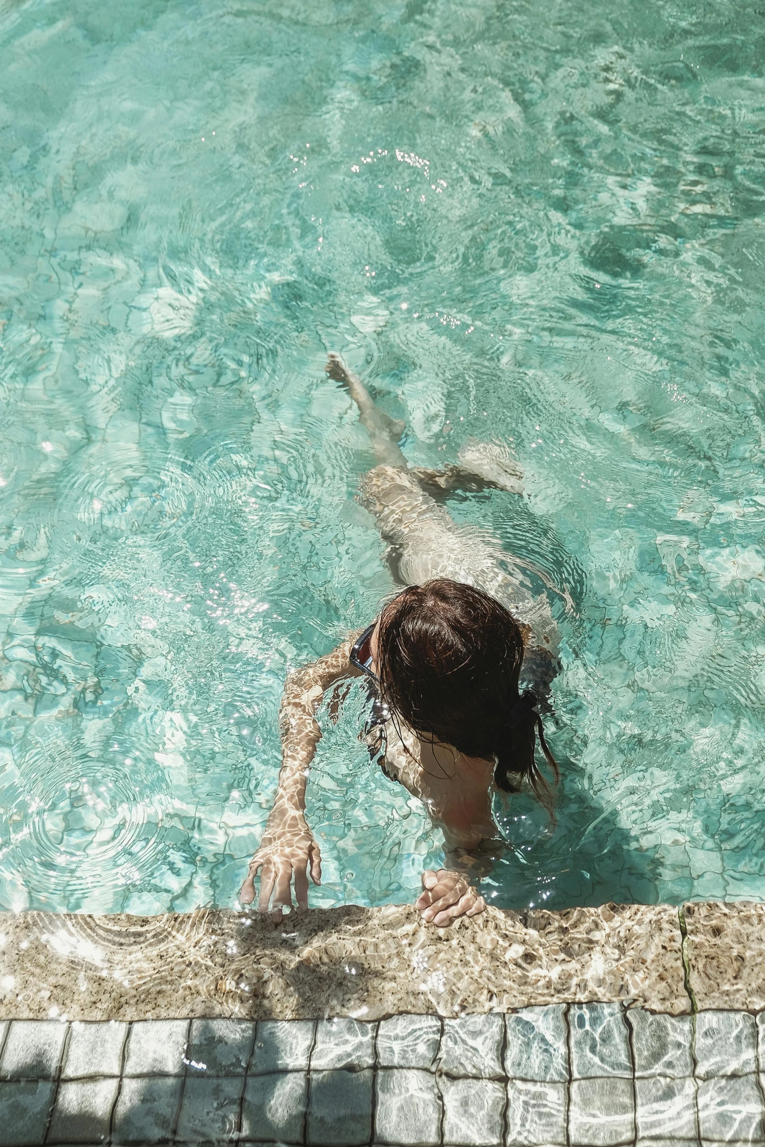 a person swimming in a pool with a frisbee, inspired by Elsa Bleda, pexels contest winner, renaissance, brunette, teal aesthetic, back facing, tan skin