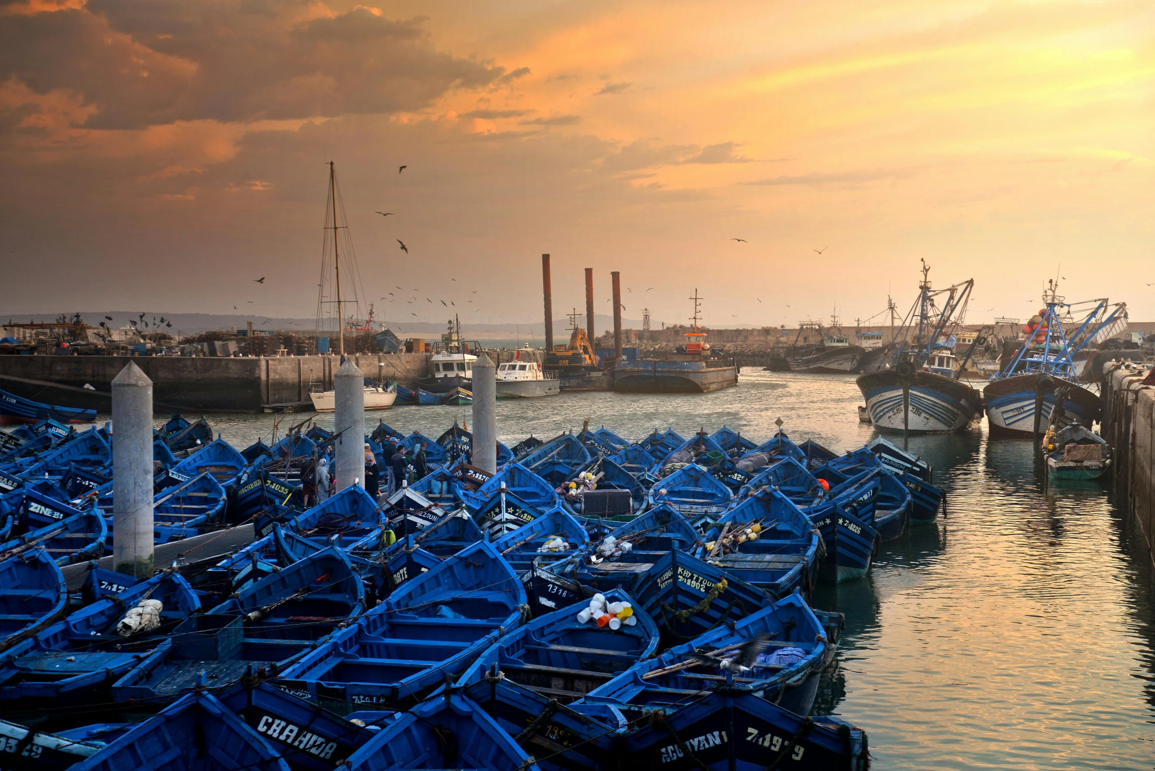 a number of small boats in a body of water, by Patrick Pietropoli, pexels contest winner, hurufiyya, warm shades of blue, moroccan, moody evening light, thumbnail