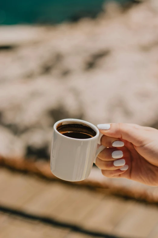 a close up of a person holding a cup of coffee, warm weather, curated collections, cliffside, multiple stories