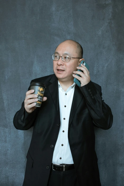 a man in a suit talking on a cell phone, inspired by Fei Danxu, pexels contest winner, hyperrealism, holding a boba milky oolong tea, danny devito, standup comedian, studio photoshot