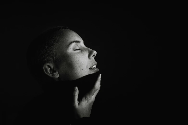 a black and white photo of a woman in the dark, pexels contest winner, minimalism, shaved head, hand on cheek, profile pic, double chin