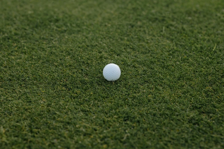 a golf ball sitting on top of a lush green field