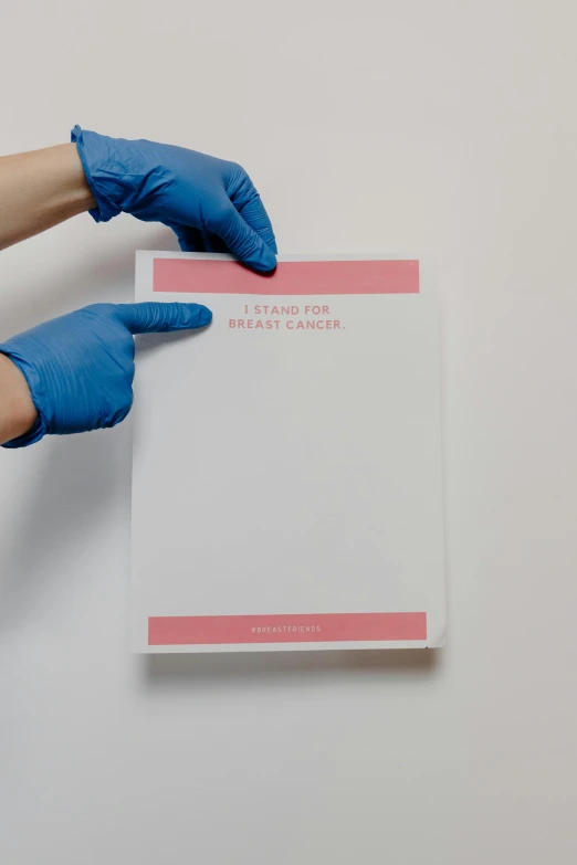 a person in blue gloves holding a piece of paper, by Julia Pishtar, private press, medical photography, (pink colors), whiteboards, back - shot