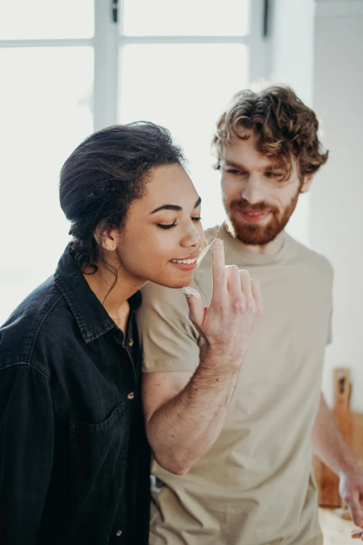 a man standing next to a woman in a kitchen, trending on pexels, sitting on man's fingertip, sideburns, pleasing, mixed race