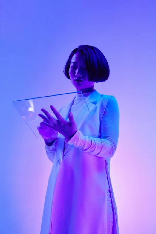 a woman in a white dress holding a tablet, inspired by Gao Cen, kinetic art, soft neon purple lighting, with a bob cut, wearing a turtleneck and jacket, transparent glass woman