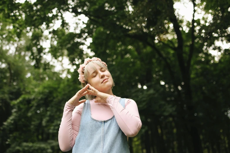a woman standing on top of a lush green field, an album cover, by Attila Meszlenyi, pexels, cute girl with short pink hair, greeting hand on head, in forest, eating