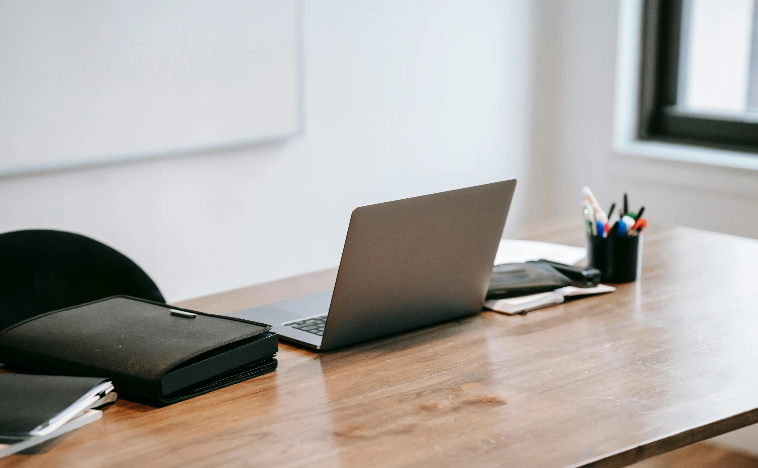 a laptop computer sitting on top of a wooden desk, trending on pexels, private press, background image, plush leather pads, multiple desks, no - text no - logo