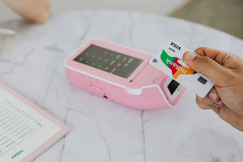 a close up of a person holding a credit card, a polaroid photo, by Julia Pishtar, private press, brightly lit pink room, cash register, built on a small, healthcare