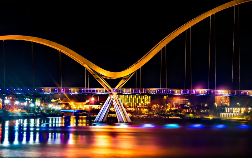 a bridge over a body of water at night, pexels contest winner, golden curve structure, brightly coloured, pittsburg, icon