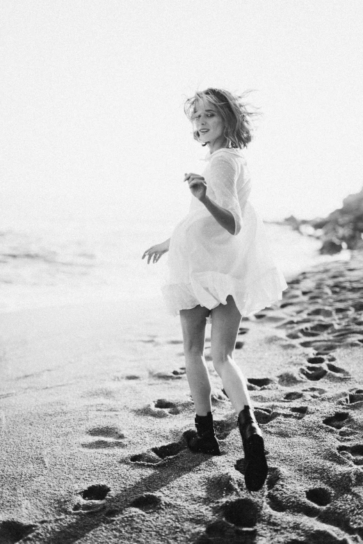 a black and white photo of a little girl running on the beach, by Lucia Peka, tumblr, happening, emma watson as blond aphrodite, 15081959 21121991 01012000 4k, wearing heels and white dress, uma thurman