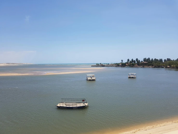 a group of boats floating on top of a body of water, hurufiyya, sandy beach, waterways, landscape photo, looking onto the horizon