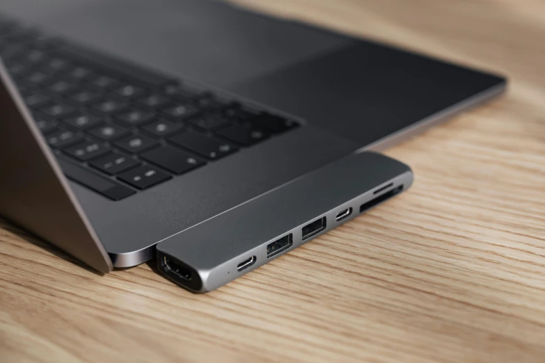 a laptop computer sitting on top of a wooden table, by Niels Lergaard, unsplash, usb ports, close up high detailed, solid gray, assemble