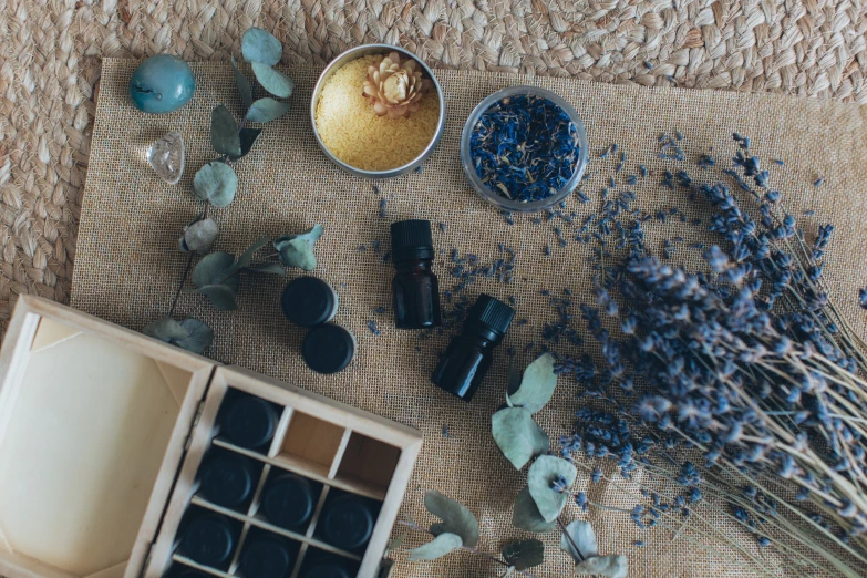 a wooden box sitting on top of a table next to a bunch of flowers, inspired by Eden Box, trending on pexels, dried herbs, black and blue and purple scheme, oils, icon