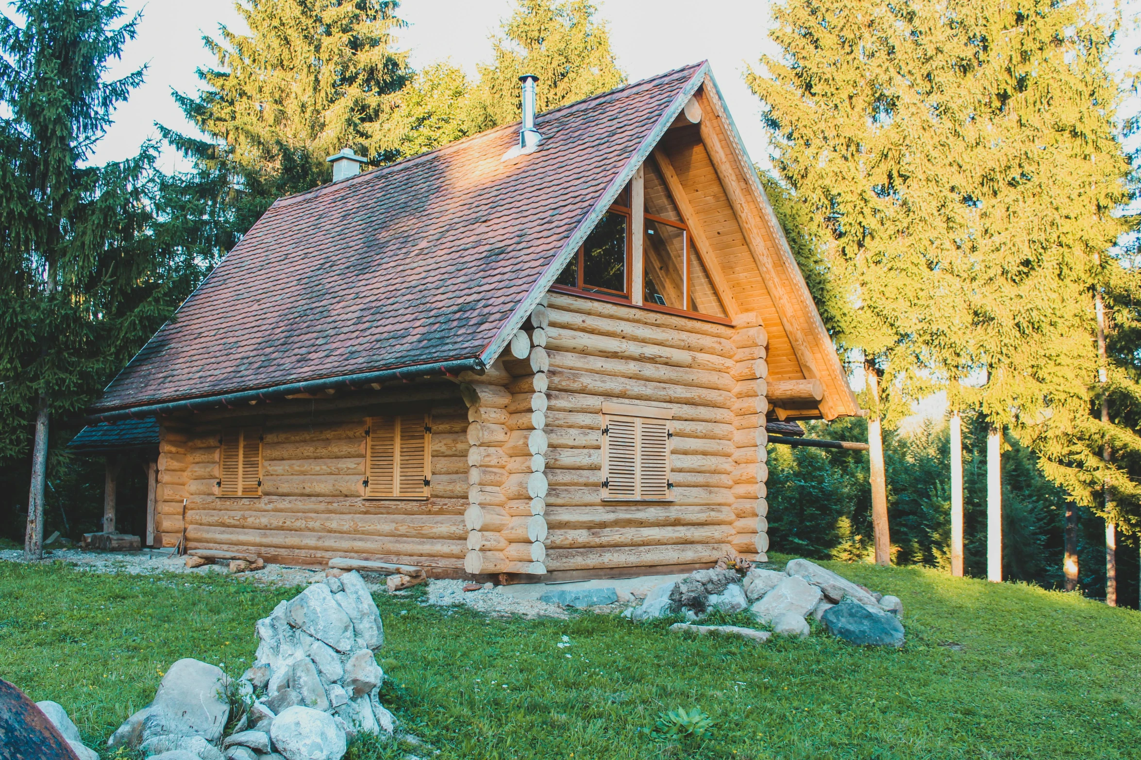 a log cabin sitting on top of a lush green hillside, by Emma Andijewska, unsplash, avatar image