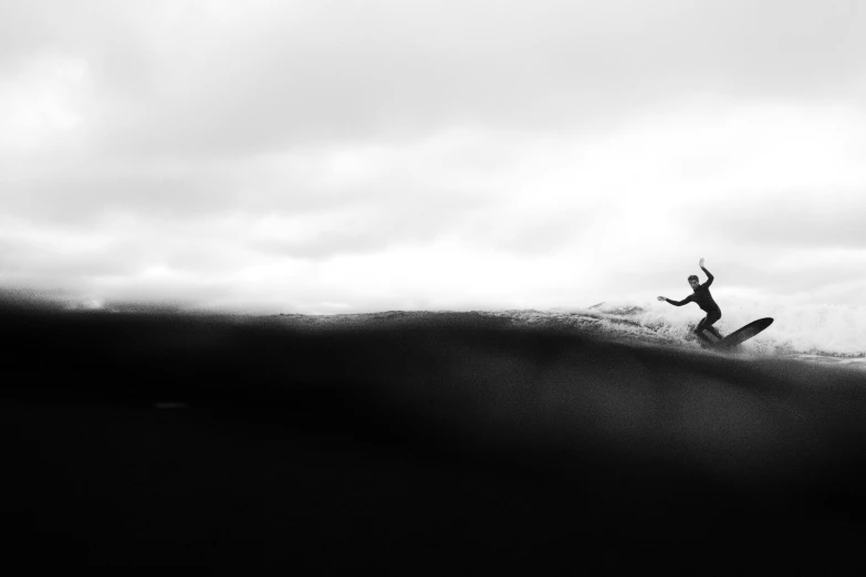 a man riding a wave on top of a surfboard, a black and white photo, unsplash contest winner, minimalism, on top of a hill, it's running between a storm, inky blackness, and burbled as it came