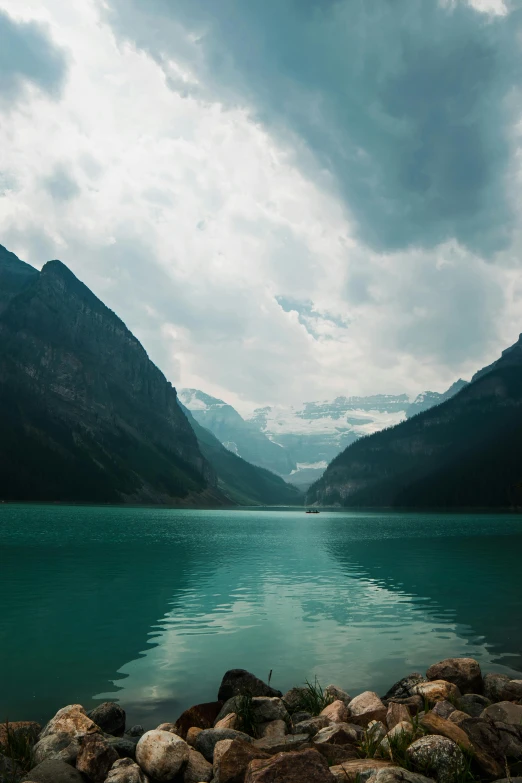 a large body of water surrounded by mountains, inspired by Elsa Bleda, pexels contest winner, banff national park, light and dark, chemistry, looking sad