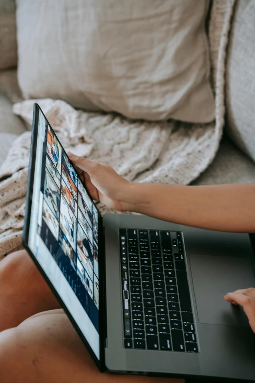 a woman sitting on a couch using a laptop computer, trending on pexels, bottom angle, movie photo, rectangle, official screenshot