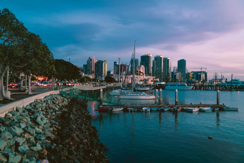 a group of boats sitting on top of a body of water, by Ryan Pancoast, pexels contest winner, city panorama, martin sandiego, summer evening, background image