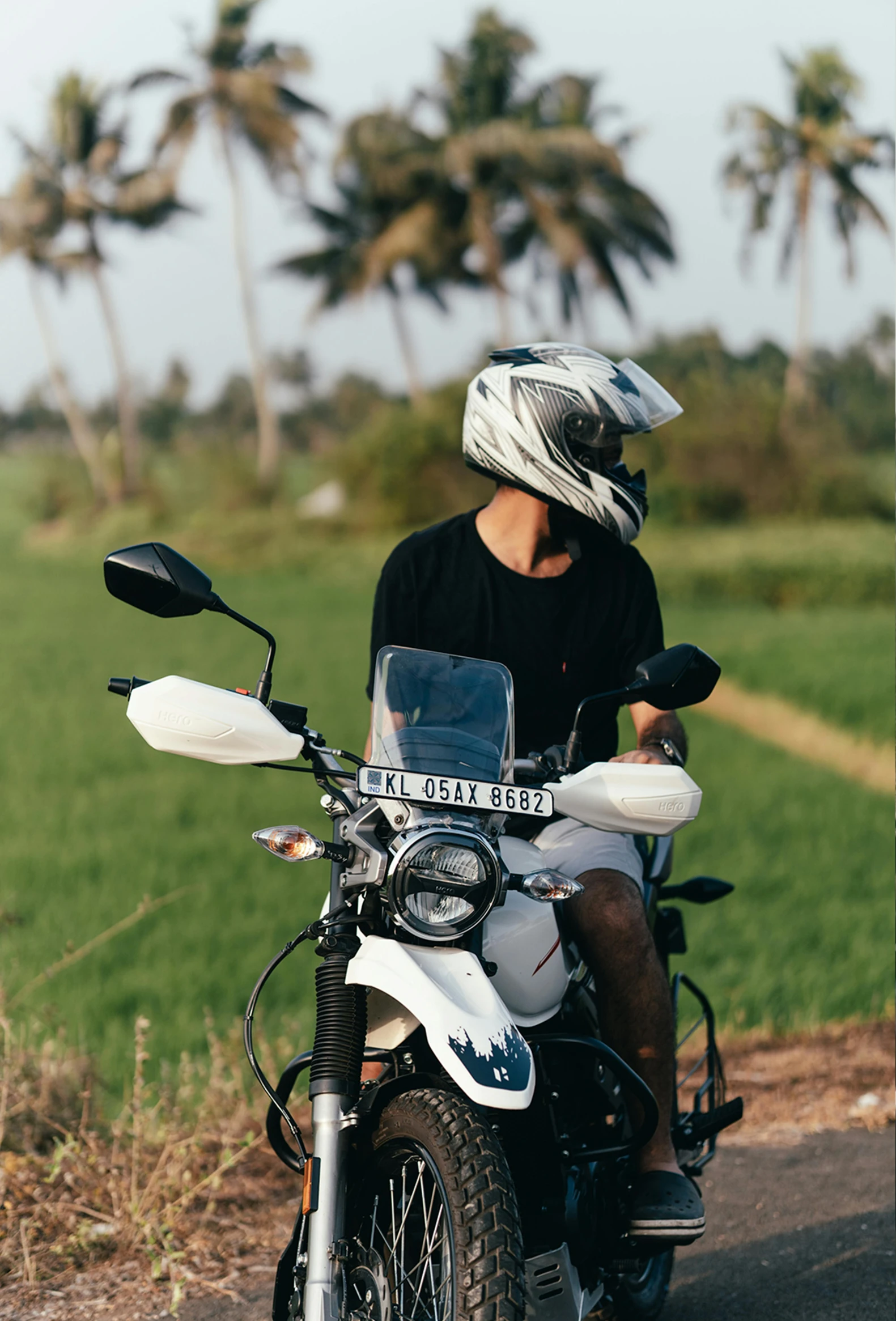 a man riding on the back of a motorcycle down a road, rice paddies, sleek visor, profile image, off-roading